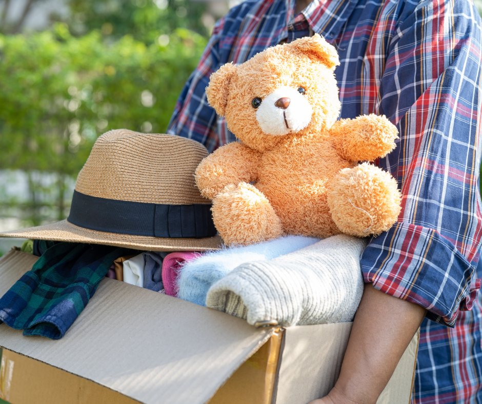 Box of preloved clothes, a hat and a soft toy ready for a doorstep donation pickup